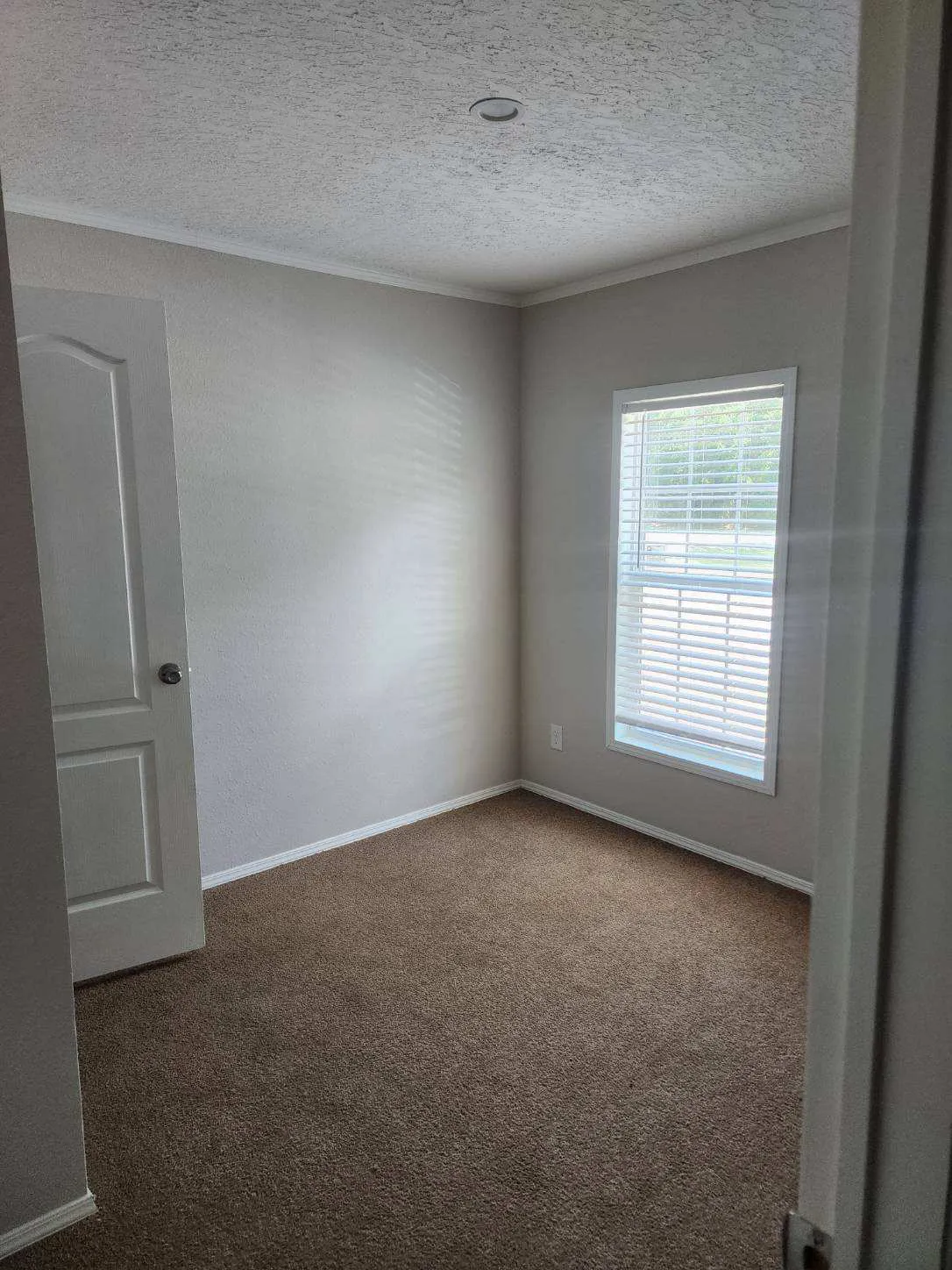 Intimate bedroom, well-lit, with natural light and a walk-in closet.